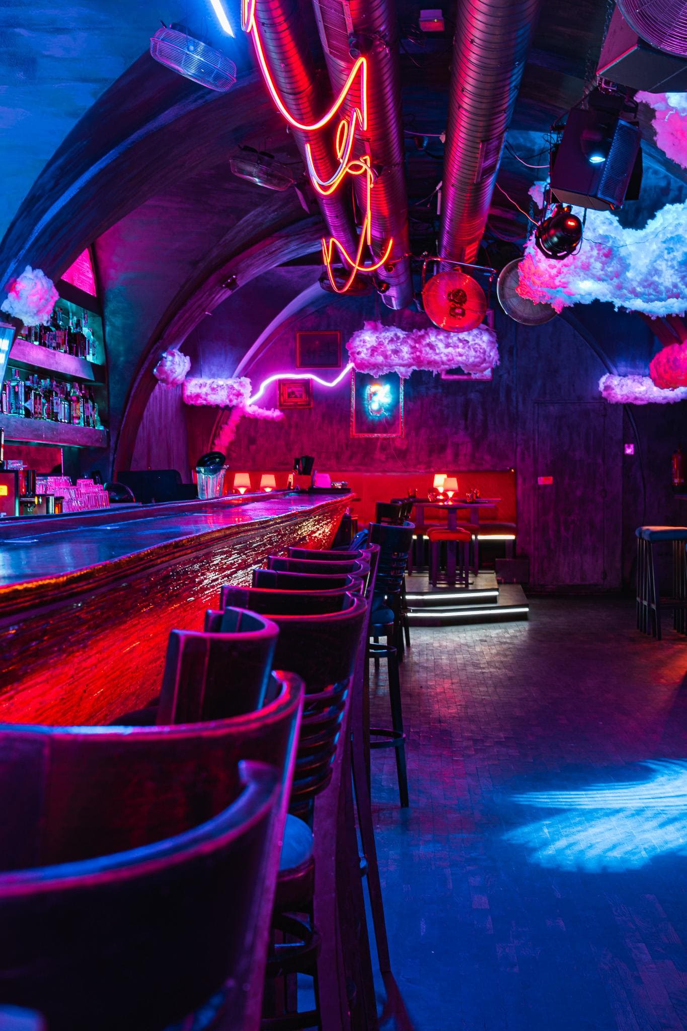 Bar counter with swivel chairs and neon tubes overhead