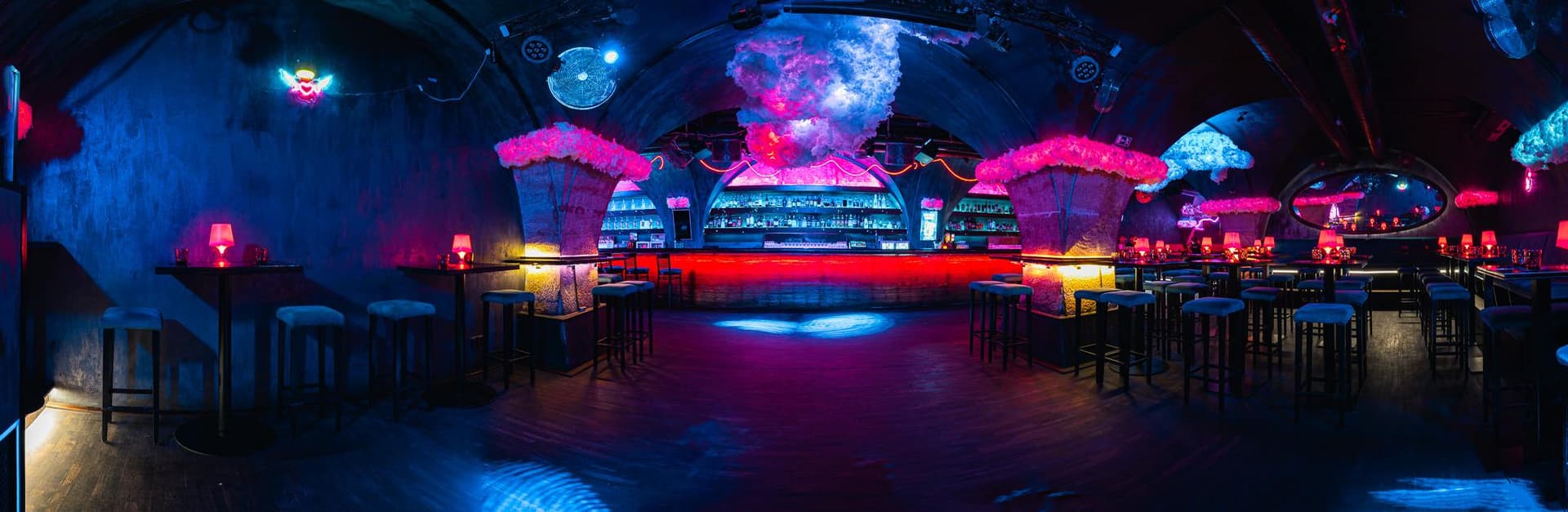 Panoramic view of the bar area lit by neon