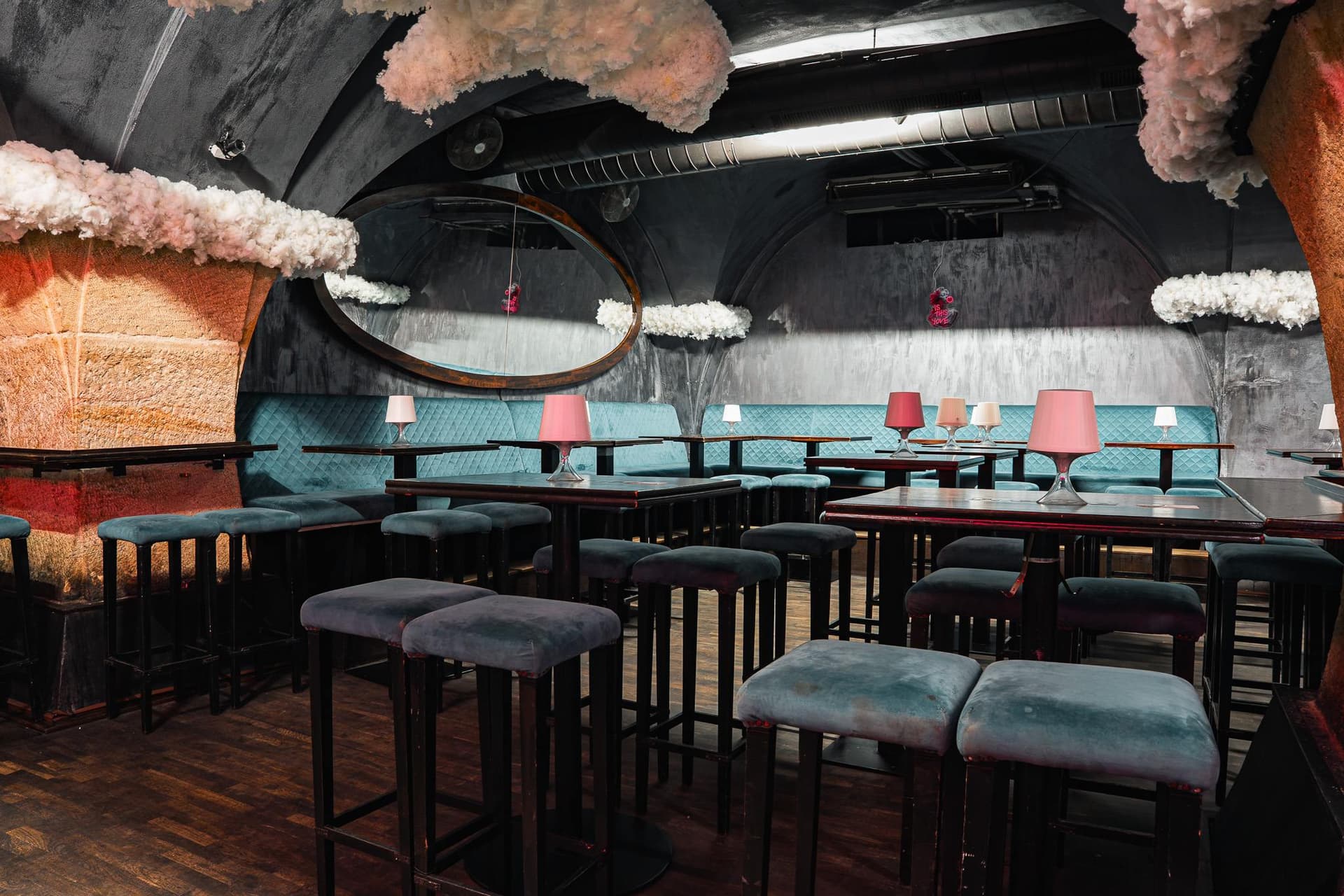 Seating with turquoise banquettes and a wooden floor