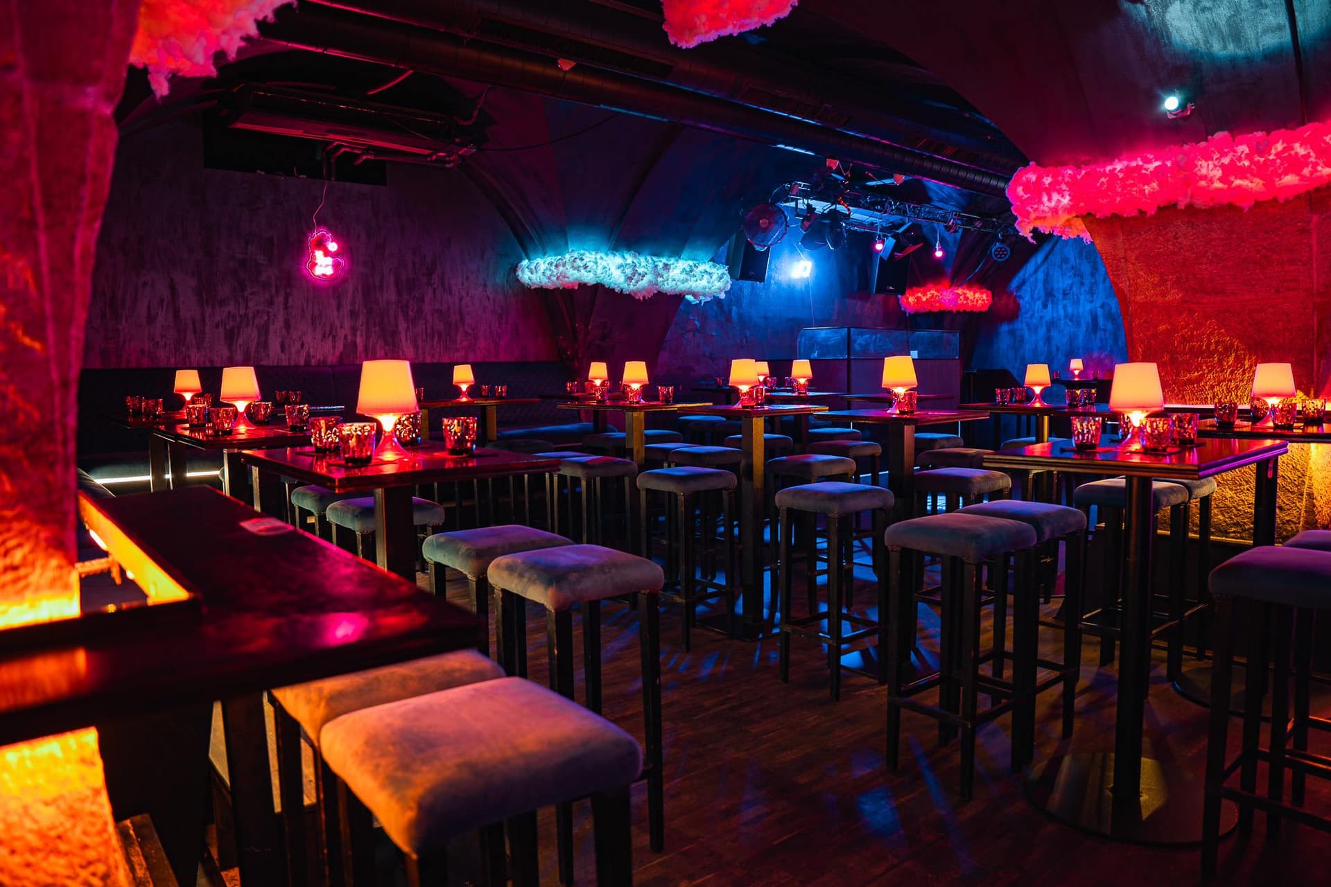 A row of bar tables and upholstered stools