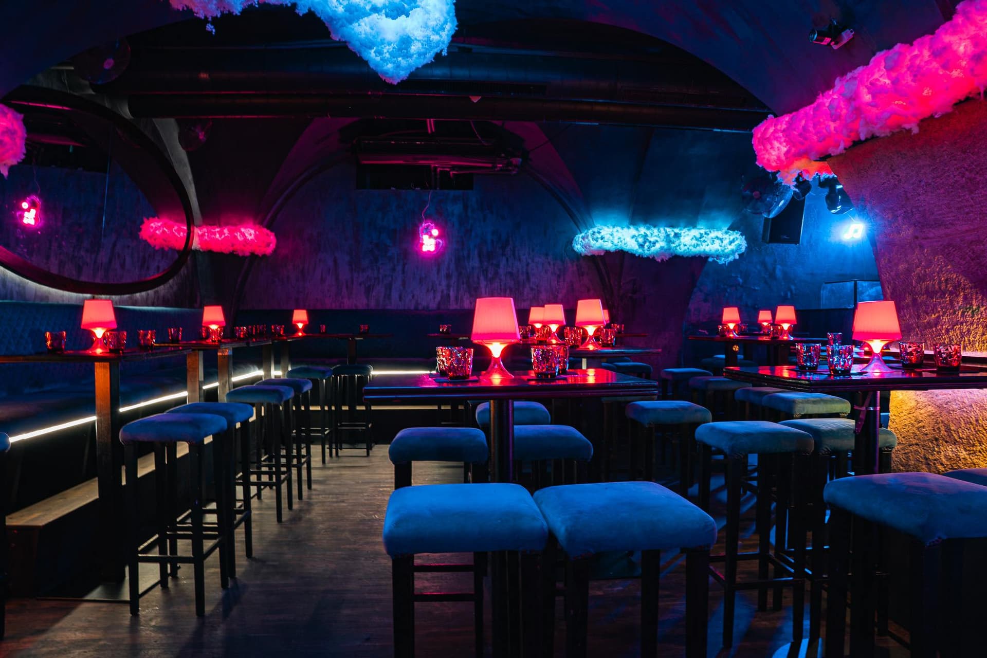 Tables with small lamps and blue stools